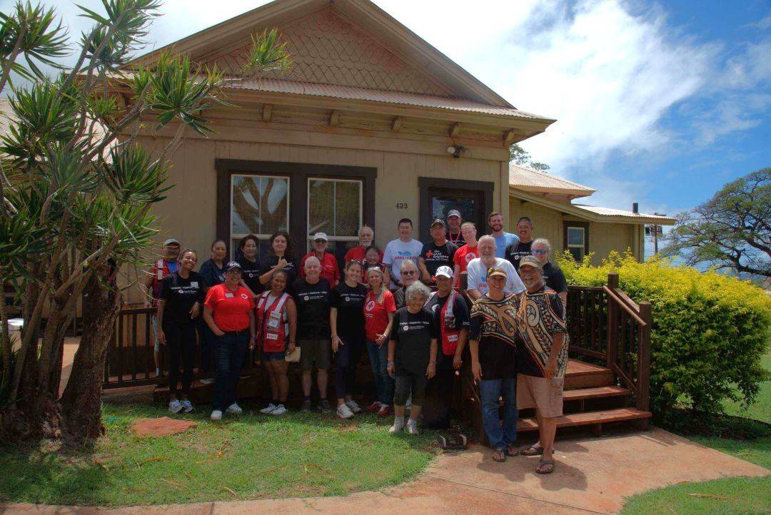 Group of Red Cross volunteers stand on porch of home