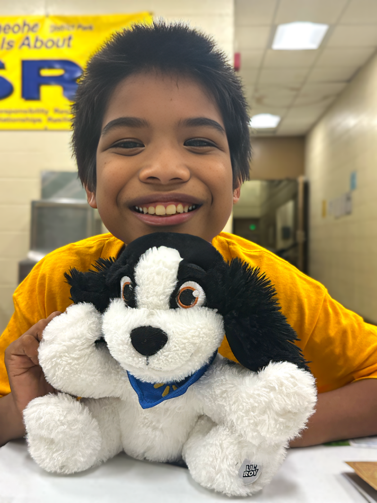 Young boy holds stuffed animal and smiles