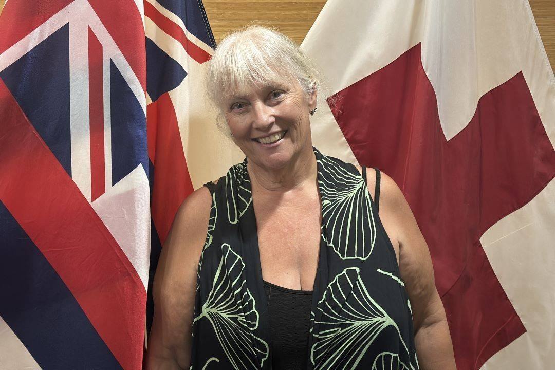 Woman stands in front of flags