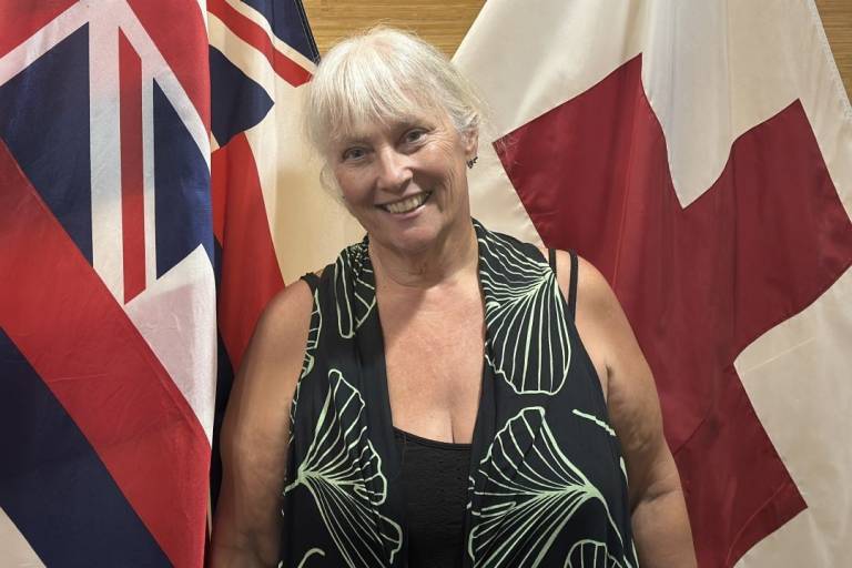 Woman stands in front of flags