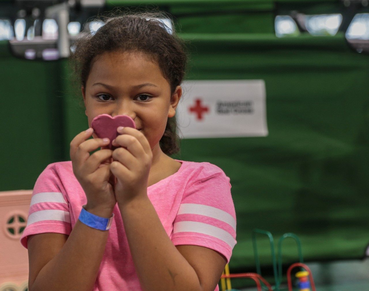 Young girl holding heart shape with both hands