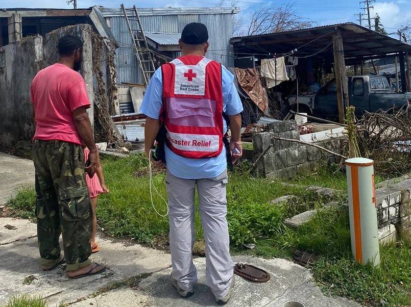 Red Cross emergency response vehicle parked among massive debris of tornado in Mississippi