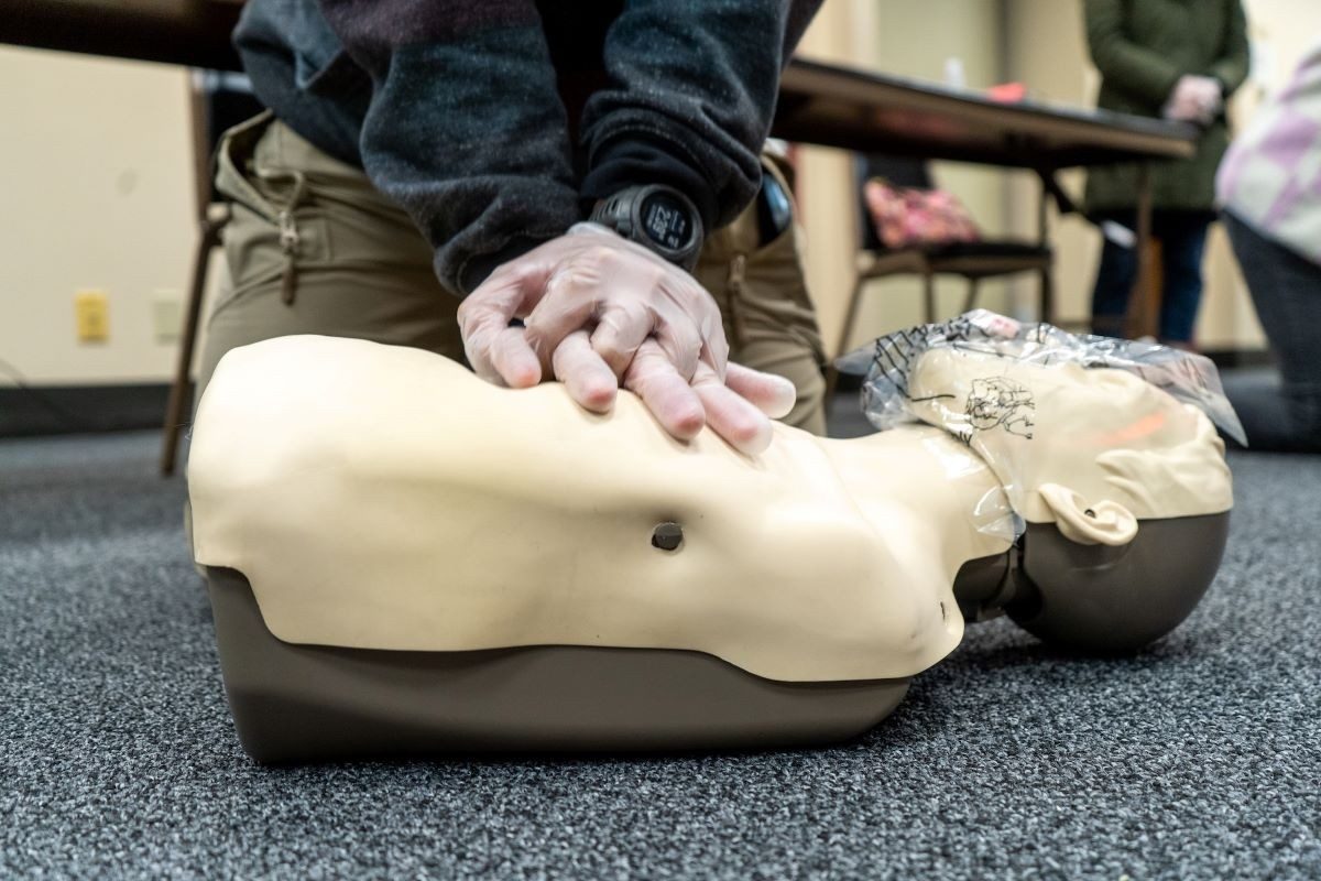 red cross volunteer performing hands only cpr.