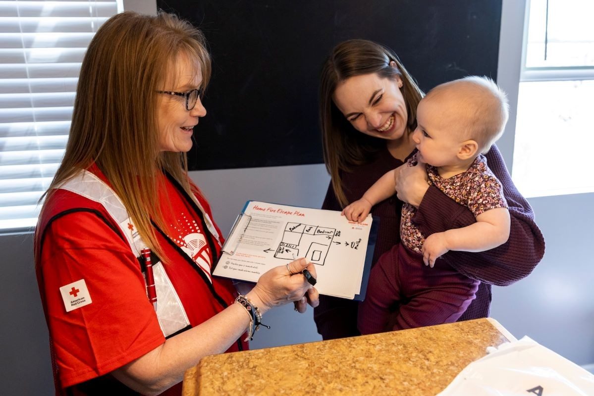 red cross volunteer pointing at emergency preparedness plan.
