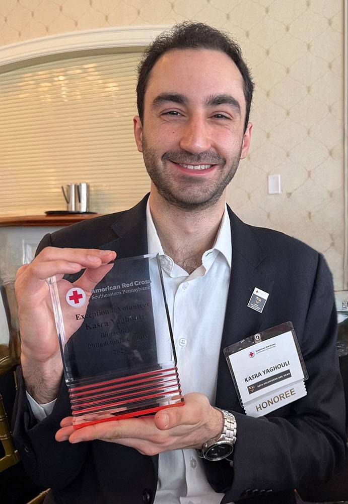 Kasra Yaghouti holding a Red Cross award.