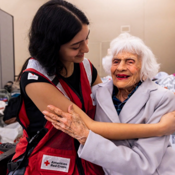 Red Cross volunteer hugging client in a shelter 