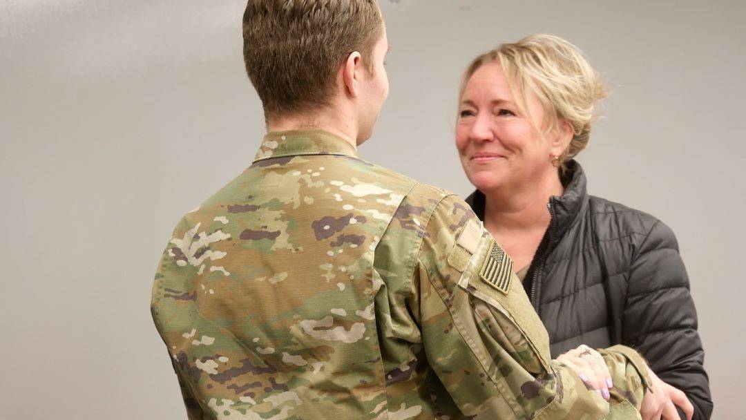 service member embraces mother