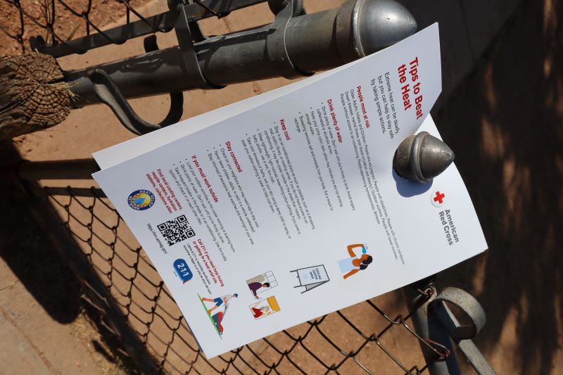 Red Cross heat flyer hanging on fence. 