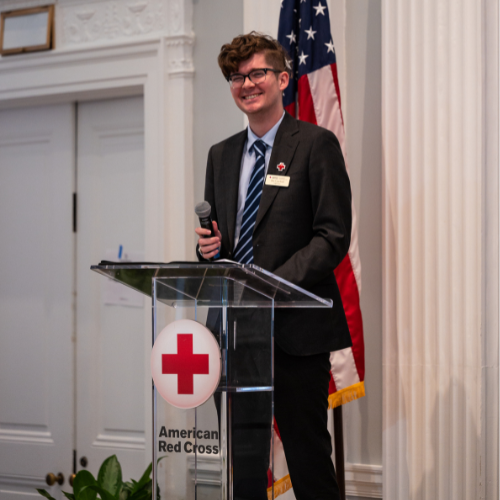a person standing at a podium with a mic in hand.