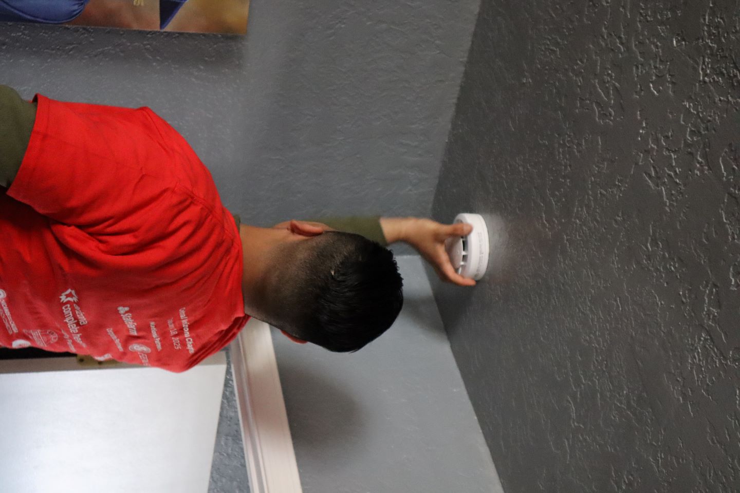 Red Cross volunteer installing smoke alarm