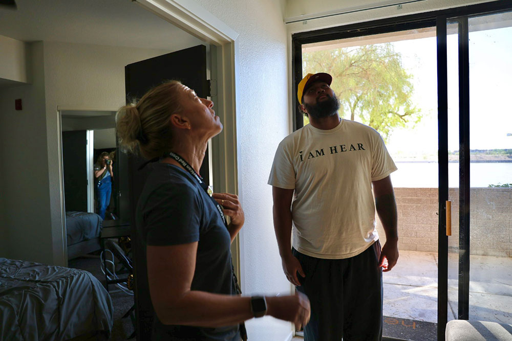 Red Cross volunteer, Paige Singer, and Joey Su’a in a bedroom looking up at the ceiling.
