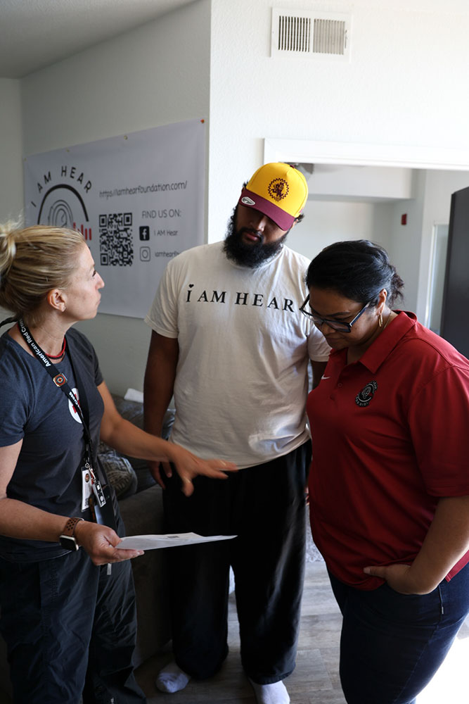 Red Cross volunteer, Paige Singer, discusses with Joey and his mother Legalo the best places to install smoke detectors in Joey’s apartment.