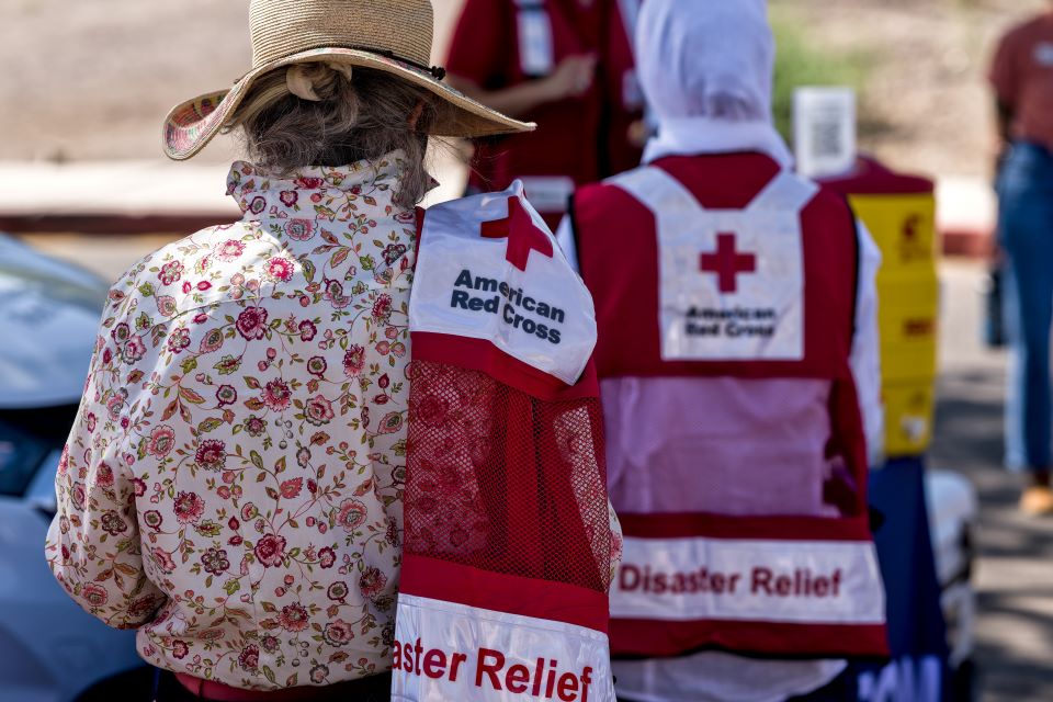 Two red cross volunteers wearing red cross vest