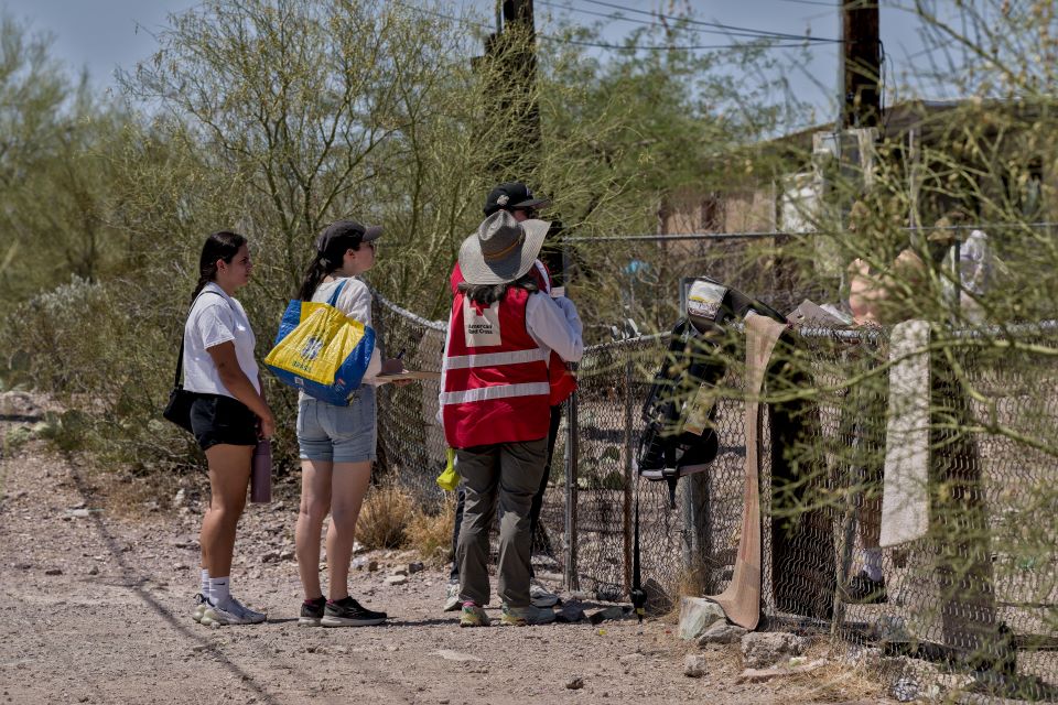 Red Cross volunteer talking to three clients 