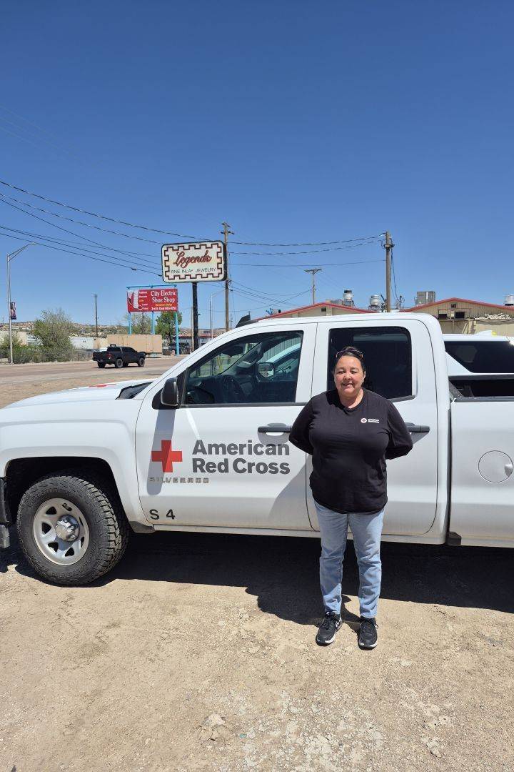Woman stands in front of Red Cross truck