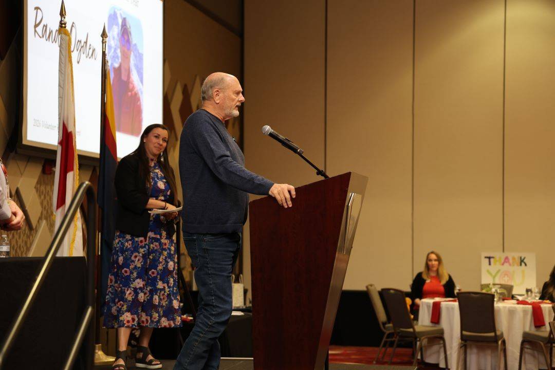 Man stands on stage and speaks into microphone