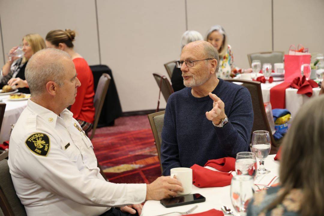 Man sits at table and discusses with firefighter