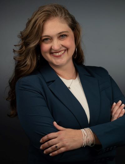 woman in blue blazer and write shirt with her arms crossed