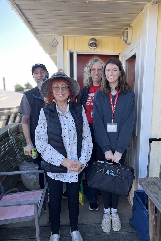 Group of volunteers stand in front of floating home