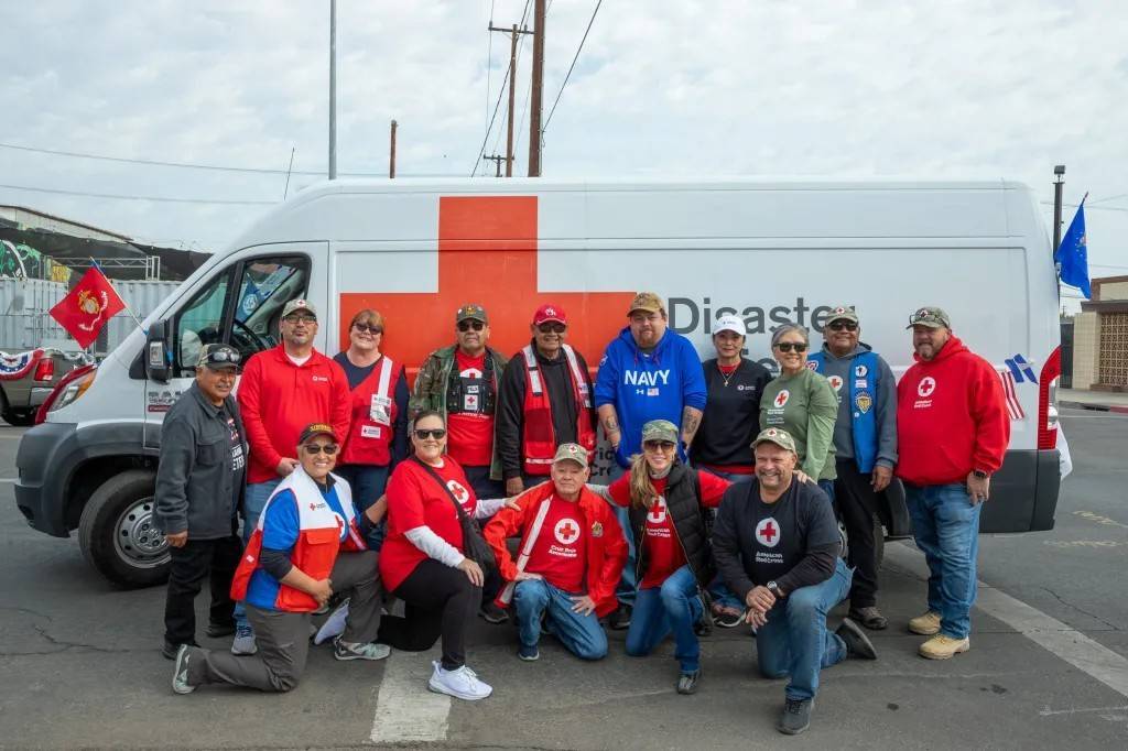 Group of Red Crossers stand in front of Emergency Response Vehicle