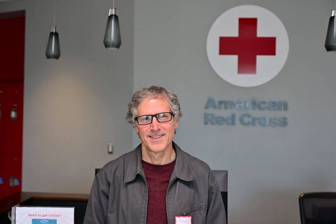 Man stands in Red Cross office in suit jacket