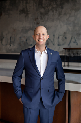 man in a blue suit smiling