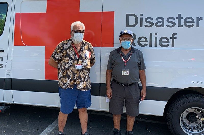 Manny Lerma and Oscar Mejia standing in front of Red Cross Disaster Relief vehicle.