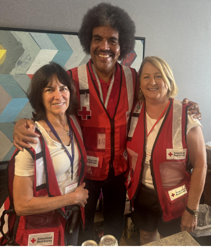 Three red cross volunteers wear vests during disaster deployment