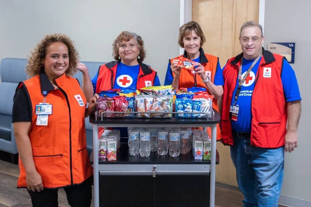 Red Cross SAF volunteers stand around snack cart
