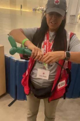 Red Cross volunteer creates balloon animal