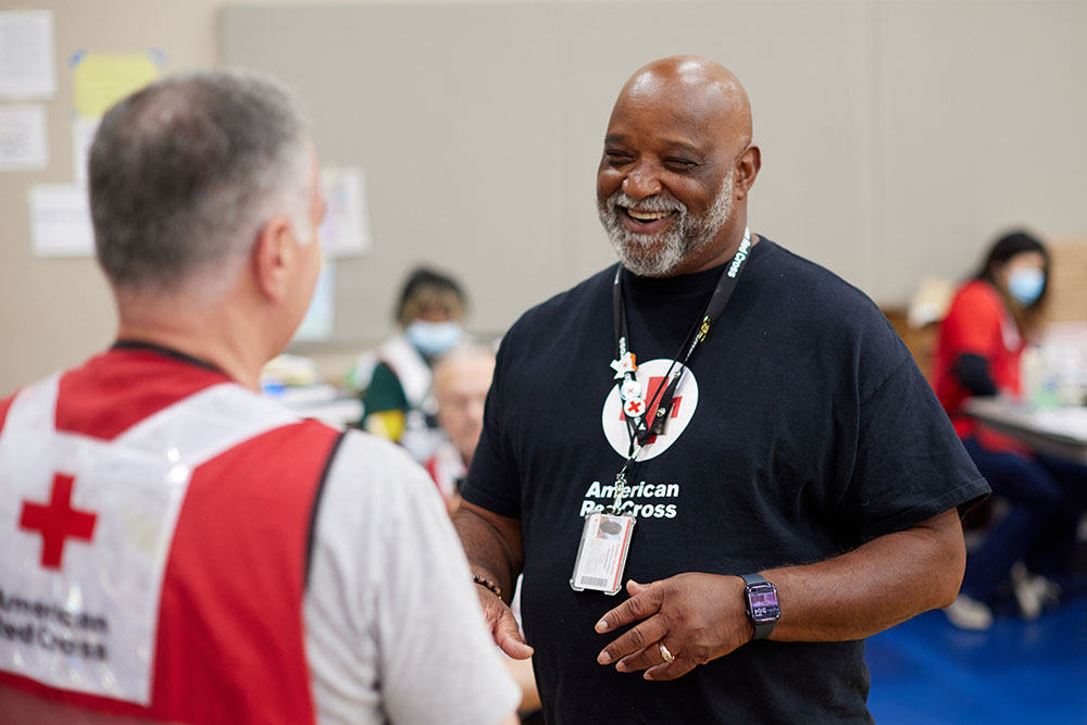 Two Red Cross volunteers interacting with each other.