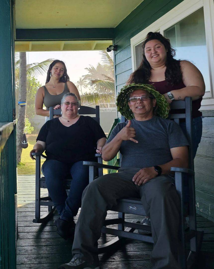 Family stands on front porch of home