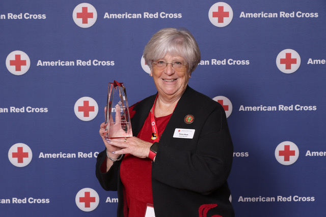 Flora B. Haus holding an award smiling for camera