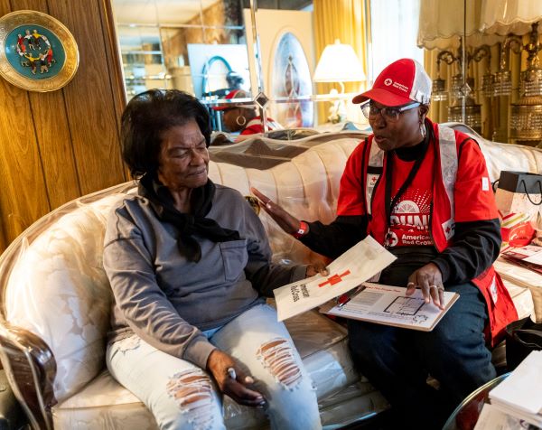 red cross volunteer helping client at home
