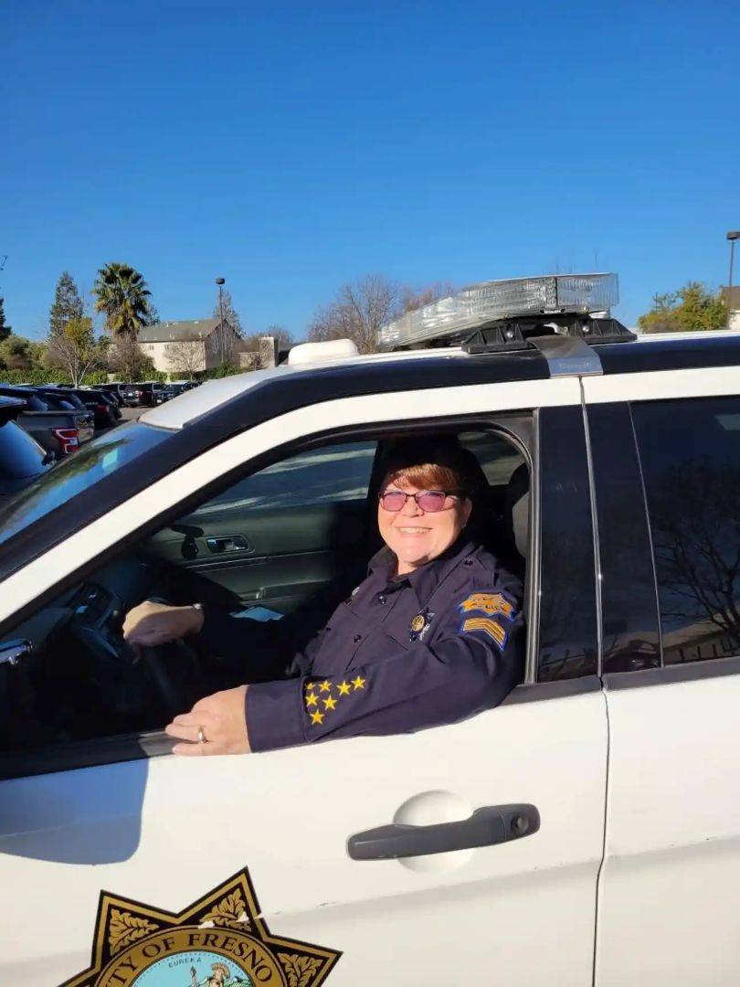 Woman sits in car in law enforcement uniform