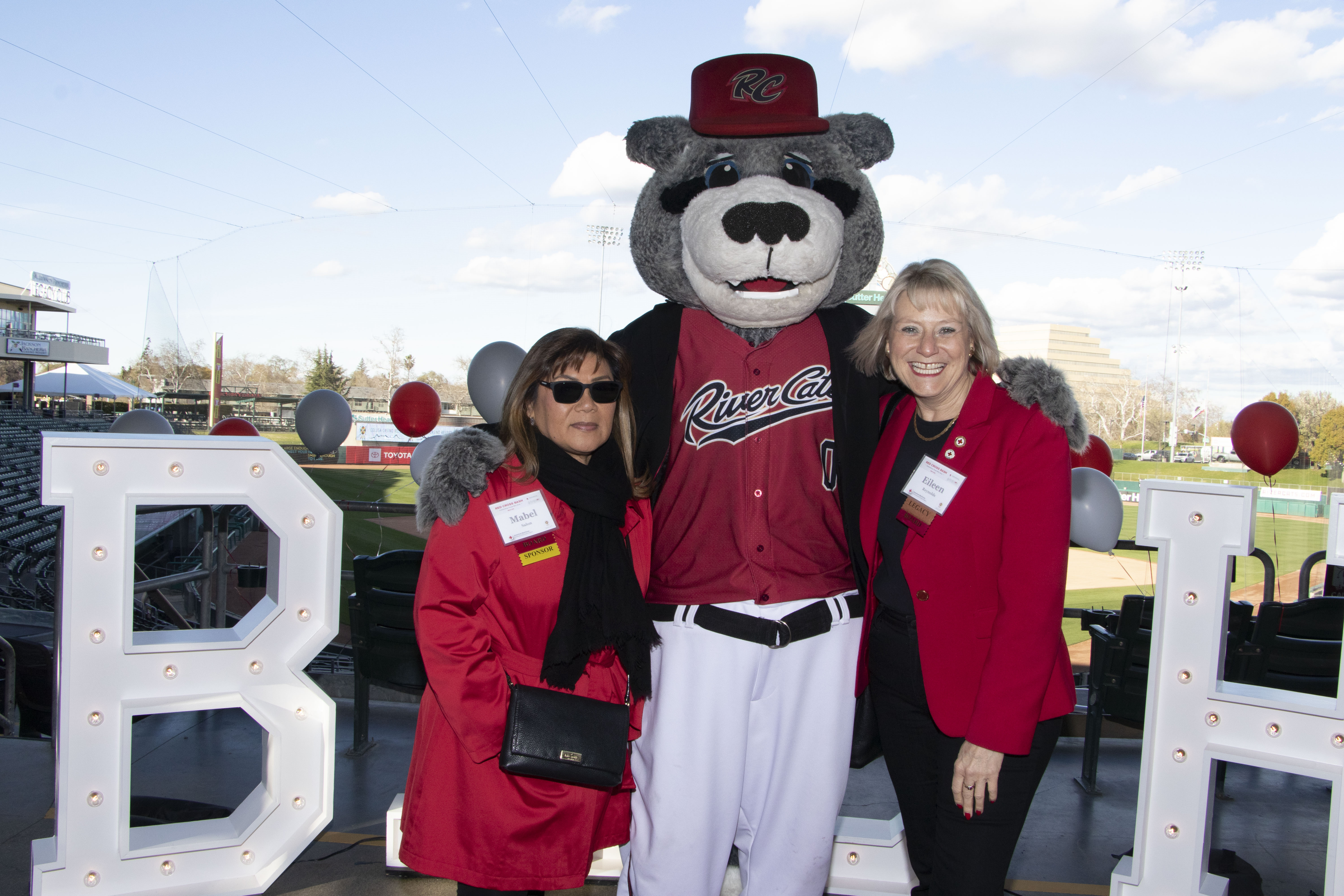 two ladies smiling with mascot