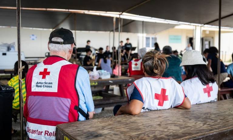 Red Cross volunteers sit at table 