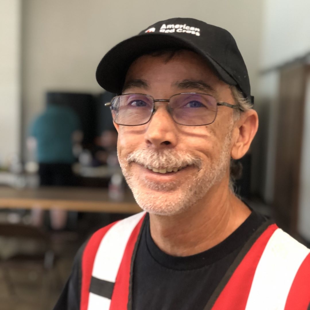 man in red cross vest