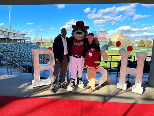two men posing with a mascot