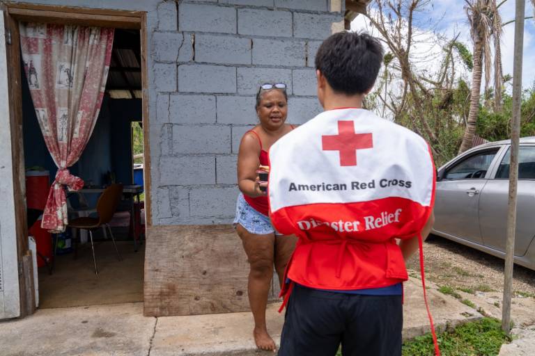 Red Cross volunteer talks with woman