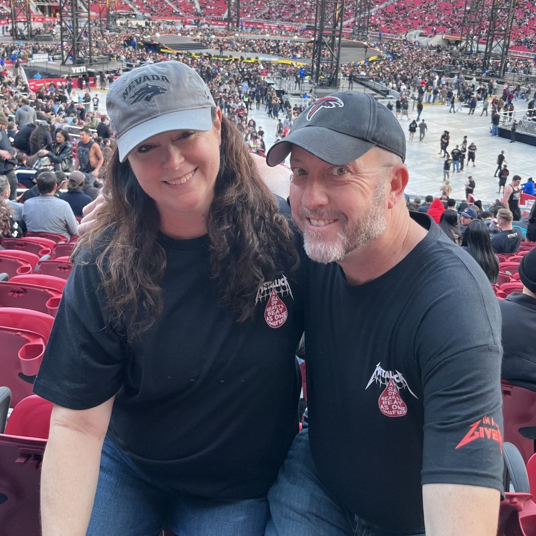man and women at concert arena in Metallica shirts
