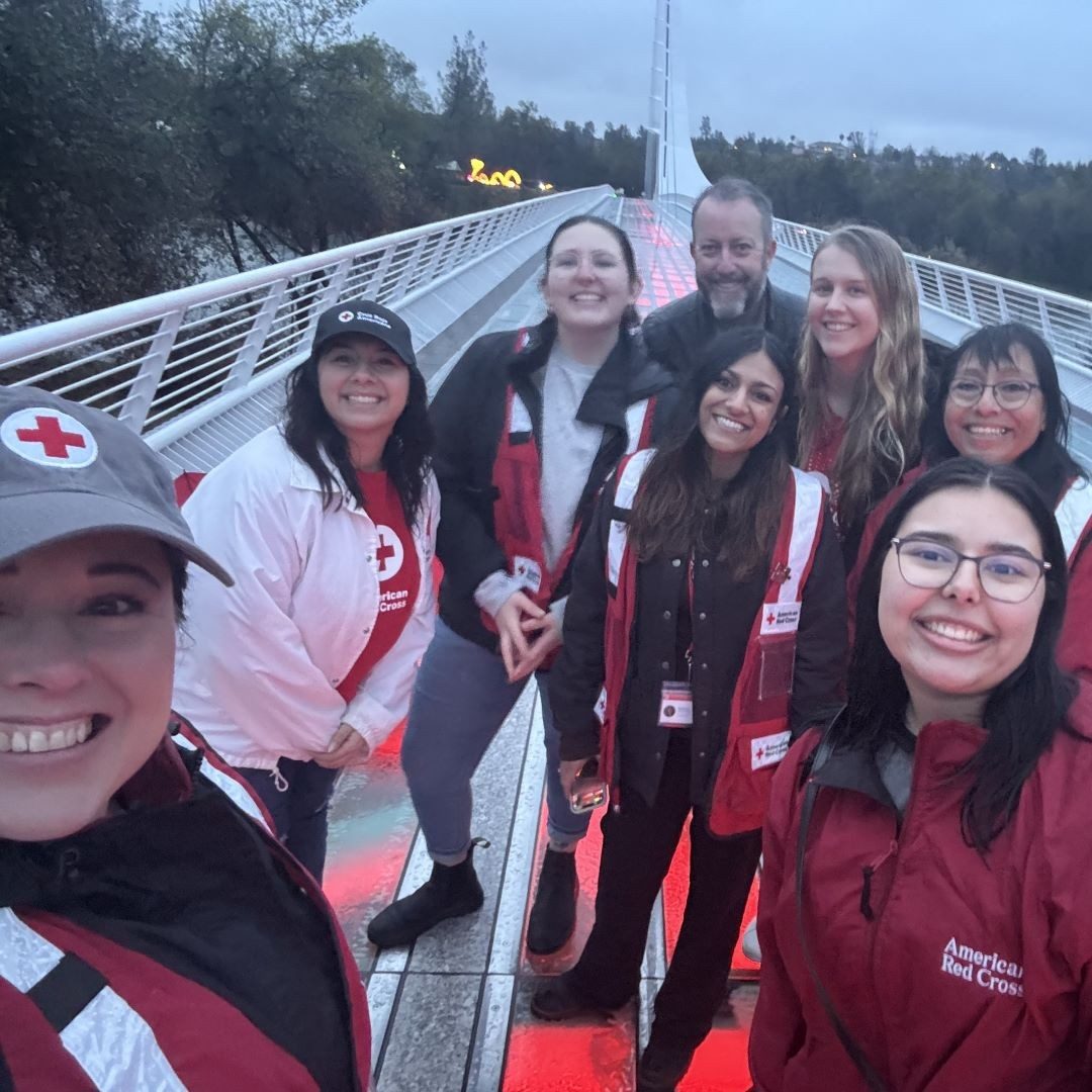 group of people in red cross branding stand on sundial bridge