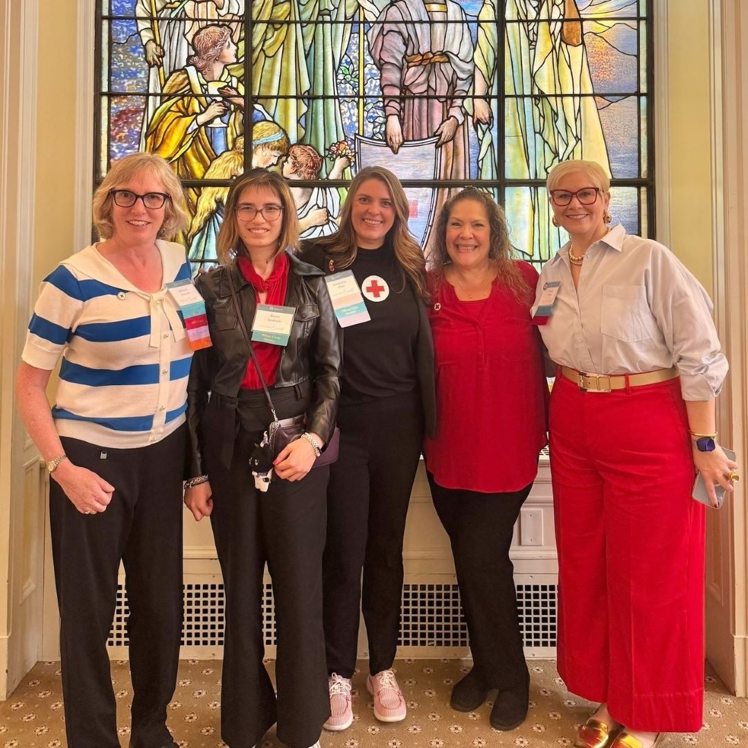 women stand in front of tiffany circle windows