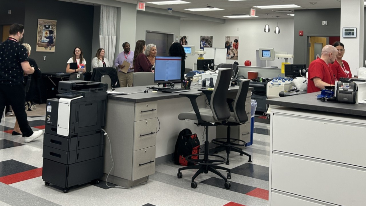 A Red Cross blood donataion site filled with people.