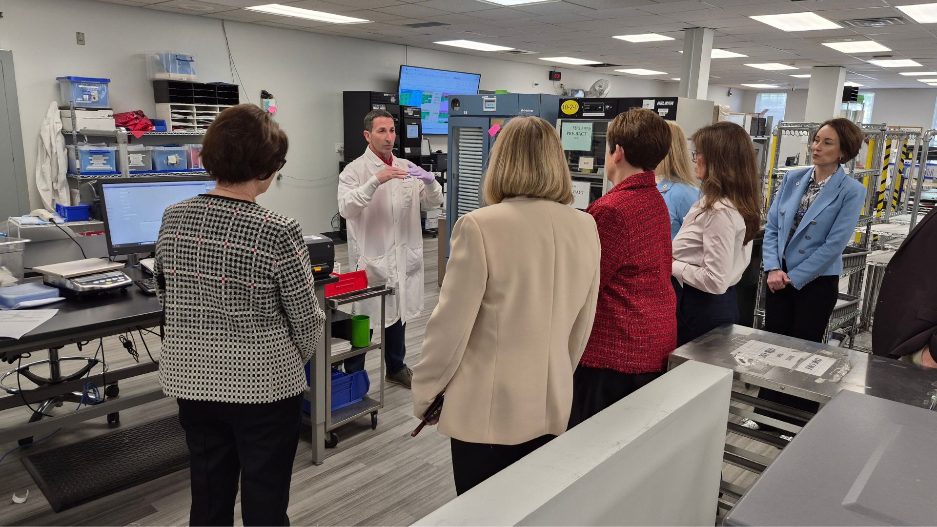 group of people in lab speaking to technician