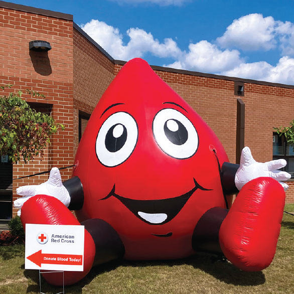 large infatable blood drop on lawn in front of office building.
