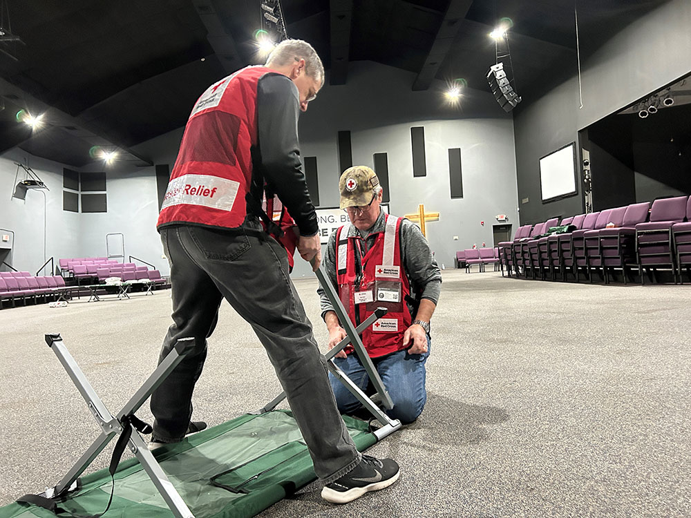 Red Cross volunteers setting up cot
