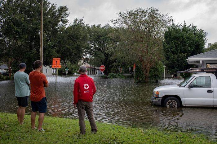 September 29, 2022. Orlando, Florida
Red Cross volunteer Dave Wagner talks with Corey Collins and Tyler Wilkins as the flood waters continue to rise in the Delaney Park neighborhood of Orlando, the morning after Hurricane Ian pummeled the Florida peninsula. Both Collins and Wilkins were out making sure their neighbors were okay. "We have a good neighborhood here," said Wilkins, "everyone here looks out for each other."
Photo by Marko Kokic/American Red Cross