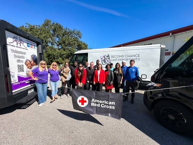 Group of people stand in front of donated vans