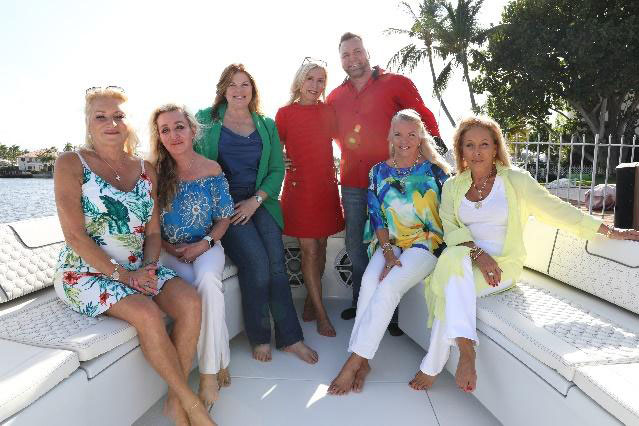 dine and dock committee members group photo while on a boat.